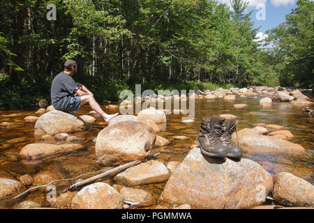 Pemigewasset Wildnis - Wanderer und Wanderschuhe trocknen weg am Felsen entlang der North Fork Ostniederlassung Pemigewasset River während der Sommermonate in L Stockfoto