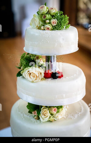 Hochzeitstorte mit Beeren und Blumen dekoriert Stockfoto