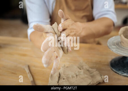 Besetzt Handwerker arbeiten hart in der Nähe von Keramik Sitzung jigger Stockfoto