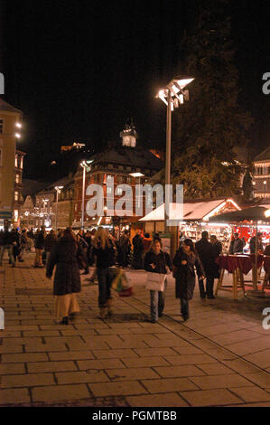 Shopper auf dem Hauptplatz des Hauptplatzes. Im Hintergrund befindet sich der Uhrenturm auf einem bewaldeten Hügel, dem Schlossberg. Stockfoto