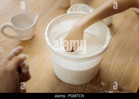 Weibliche Potter ihre Hand in Ton Substanz Stockfoto