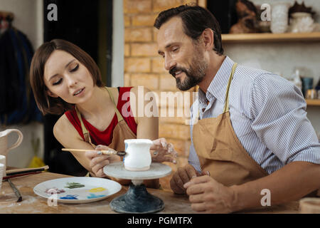 Dunkelhaarige Frau potter Malerei wenig Tontopf Stockfoto