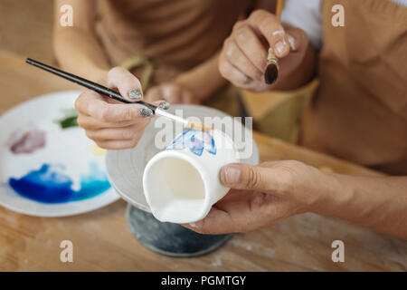 Paar Künstler Malerei Blumen auf kleinen Tontopf Stockfoto