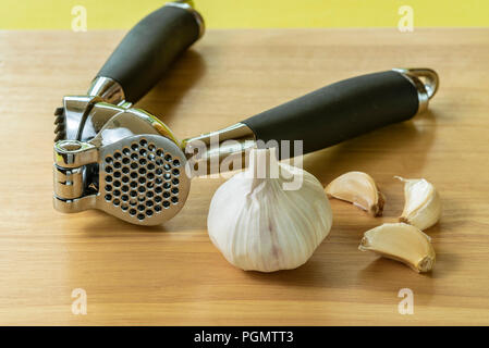 Knoblauch crusher oder drücken Sie mit einer Glühlampe und Nelken. Stockfoto