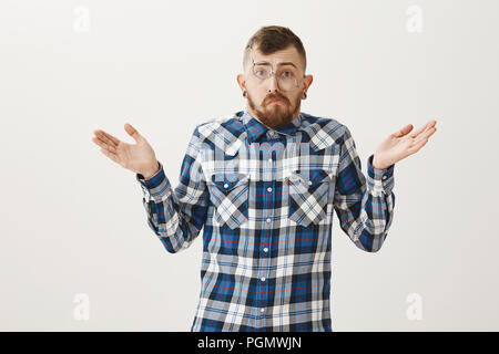 Kerl aufgeben und sich weigern, dating nach Auseinanderbrechen. Portrait von Elenden unordentlich erwachsener Bruder in Blue Plaid Shirt und Brille, von Gesicht, Achseln und Verbreitung Palmen in Verwirrung, nicht bewusst Stockfoto