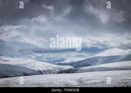 Dramatische Himmel über verschneite Hügel, Cairngorms National Park, Schottland Großbritannien Stockfoto