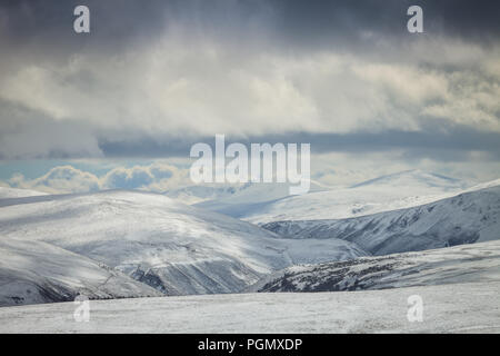 Dramatische Himmel über verschneite Hügel, Cairngorms National Park, Schottland Großbritannien Stockfoto