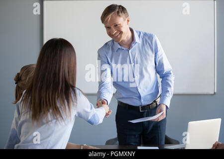 Lächelnd Geschäftsmann handshake Arbeiterin Begrüßung mit Promot Stockfoto