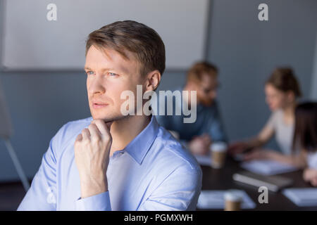 Nachdenklich männliche Mitarbeiter sieht in der Entfernung denken über Erfolg Stockfoto