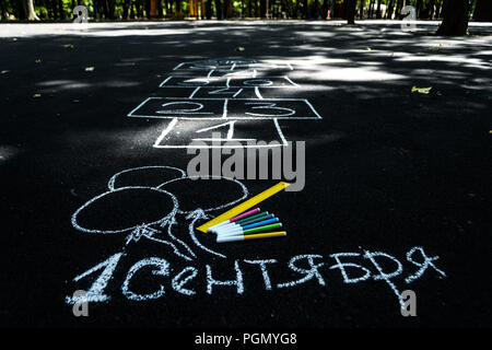 Weißer Kreide auf den schwarzen Asphalt Gedenkstein in russisch September 1. Gelbe Linie, farbige Markierungen, bemalt Kugeln, Hopse Stockfoto