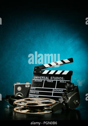 Vintage film claper mit Filmrolle und Kamera. Filmemacher Ausrüstung Hintergrund Stockfoto