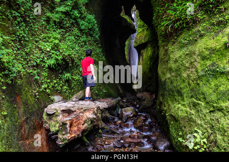 Wanderer erkunden Wasserfall in der Nähe von sombrio Beach, Juan de Fuca Provincial Park - in der Nähe von Port Renfrew, Vancouver Island, British Columbia, Kanada Stockfoto