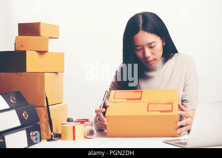 Closeup hand jungen asiatischen Teenager Eigentümer Business woman binden ein Seil Vorbereitung Paket das Produkt mit Büroausstattung online shopping, Unternehmer Stockfoto