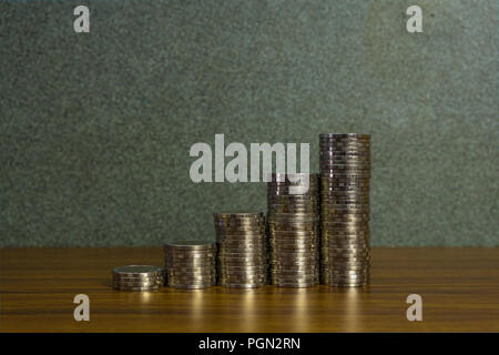 Einsparungen, Erhöhung der Spalten von Goldmünzen, Stapel von Goldmünzen als Grafik auf Schreibtisch, Business Banking Idee. Stockfoto