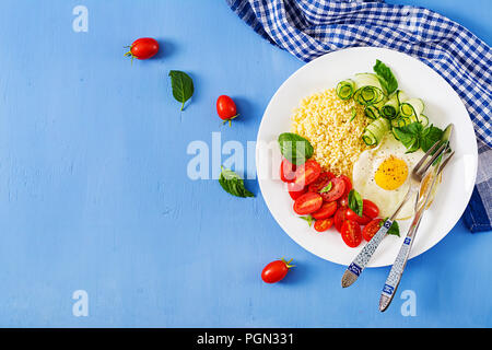 Gesundes Frühstück. Diätetisches Menü. Millet Porridge und Tomaten, Gurken Salat und gebratene Eier. Ansicht von oben. Flach Stockfoto