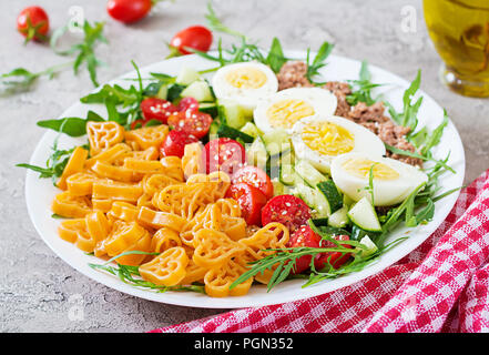 Nudelsalat mit frischem Gemüse, Eier und Thunfisch in einer weißen Schüssel. Mittag essen. Stockfoto