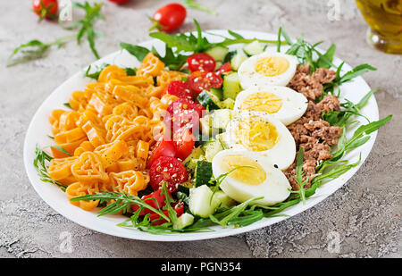 Nudelsalat mit frischem Gemüse, Eier und Thunfisch in einer weißen Schüssel. Mittag essen. Stockfoto