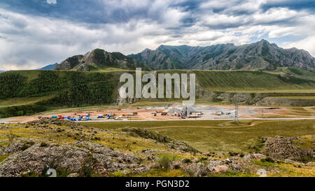 Panoramablick auf große Bau einer Industrieanlage in den Bergen mit Hilfe von Kränen, Lkw und andere spezielle Ausrüstung agai Stockfoto