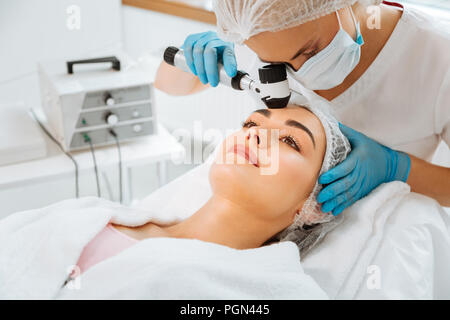 Angenehme schöne Frau, die eine ärztliche Untersuchung Stockfoto