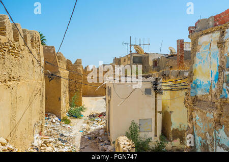 Die verlassenen Hinterhöfen an der mittelalterlichen Stadtmauer in Medina sind durch Lokale Workshops für Müllkippe, Sfax, Tunesien verwendet. Stockfoto