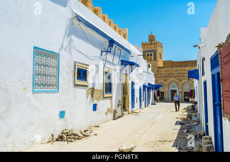 KAIROUAN, TUNESIEN - 30. AUGUST 2015: Die engen Gassen der Medina mit Blick auf drei Türen Moschee, mit geschnitzten Stein und Ziegel Mustern verziert, auf Stockfoto