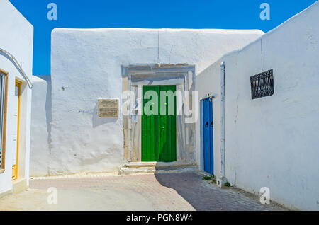 KAIROUAN, TUNESIEN - 30. AUGUST 2015: Die engen Gassen der Medina mit Blick auf das Eingangstor von Sidi Abdeljabbar Moschee, am 30. August in Kairoua Stockfoto