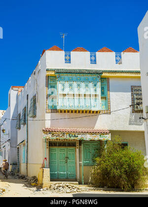 KAIROUAN, TUNESIEN - 30. AUGUST 2015: Die malerische weiße Villa mit farbigen Türen und Balkone, mit schönen Mustern verziert, der am 30. August in Kairouan Stockfoto