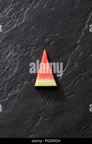Frische organische Wassermelone Schicht auf einem schwarzen Stein. Stockfoto