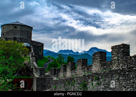 Festung der Verrucole in der Garfagnana, mittelalterliche Burg mit schneebedeckten Bergen im Hintergrund und bewölkter Himmel Stockfoto