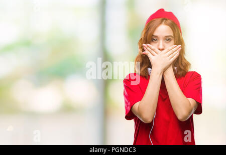 Junge schöne hipster Frau über isolierte Hintergrund das Tragen von Kopfhörern und Kappe schockiert über den Mund mit Händen für Fehler. Geheime Konzept. Stockfoto