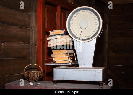 Braun Warenkorb und Alte Waage, auf dem es gibt Bücher auf dem Tisch Stockfoto