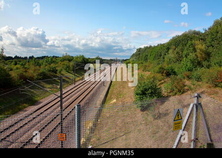 Die hohe Geschwindigkeit der Leitung durch Kent neben der M20 in Kent mit doppelter Linie und Oberleitung für die Traktion untis hier ausgeführt. Stockfoto