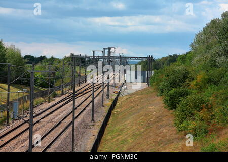 Die hohe Geschwindigkeit der Leitung durch Kent neben der M20 in Kent mit doppelter Linie und Oberleitung für die Traktion untis hier ausgeführt. Stockfoto