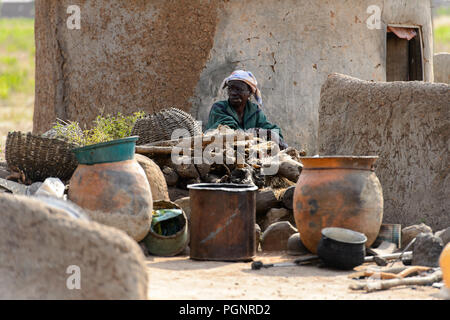 GHANI, GHANA - Jan 14, 2017: Unbekannter Ghanaischen alter Mann raucht in der Nähe des Hauses in der ghani Dorf. Ghana Menschen leiden unter der Armut aufgrund der schlechten e Stockfoto