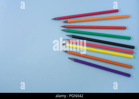 Bunte Bleistifte auf Pastell blau Schreibtisch platziert, Platz für Text auf der linken Seite. Stockfoto