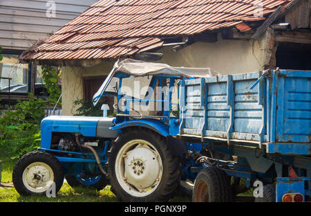 Blaue Traktor Parken im Hof des alten, alten Haus. Bereit zu arbeiten. Stockfoto