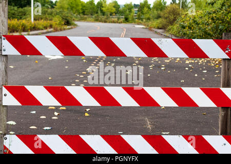 Straße Block Barrikade zeichen Streifen in Weiß und Rot mit der Straße hinter Stockfoto