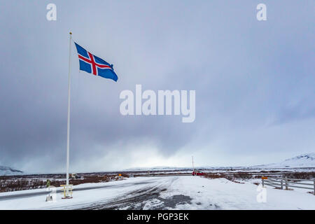 Eine zivile Flagge und Fähnrich Island gegen einen bewölkten Himmel. Die Nationalflagge der Isländer ist blau wie der Himmel mit einem Schnee-weißen Kreuz und eine feurig-r Stockfoto