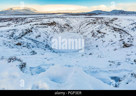 Panoramablick auf die kerid Vulkan mit Schnee und Eis in den vulkanischen Krater See im Winter unter einem klaren blauen Himmel. Im Bereich Grímsnes, entfernt Stockfoto