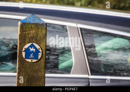 Ein öffentlicher Weg Zeichen zeigen Richtungen für Pferd, Reiter und Radfahrer; ein Auto im Hintergrund; britische Landschaft Stockfoto