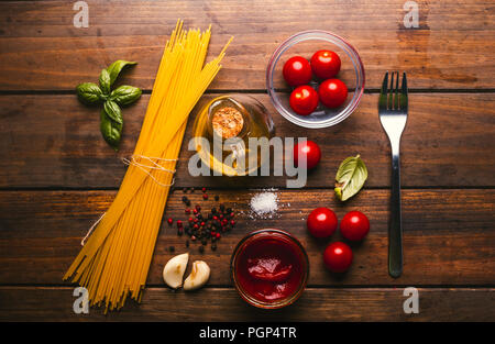 Pasta mit verschiedenen Zutaten zum Kochen Italienische Küche, auf einem rustikalen Holztisch Stockfoto