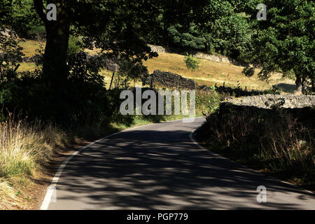 Sie suchen in einem leichten Bogen auf ein Land Hill Lane gerade innerhalb des Peak District National Park in der Nähe von Bradfield, Sheffield Stockfoto