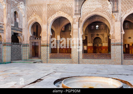 Marokkanische Moschee Innenhof, mit Reihen von Bögen mit kunstvollen Fliesen und Bemalung. Ort: Fes, Marokko Stockfoto