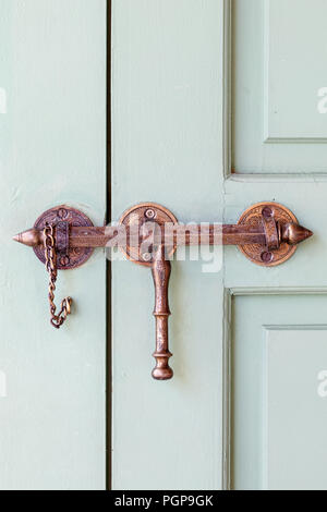 Marokko Marrakesch verzierten Messing Riegel auf eine lackierte Tür. Lokale hardware Stil. Stockfoto