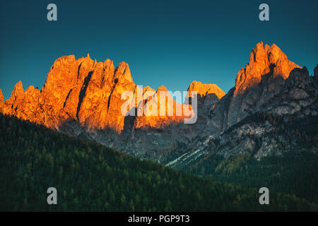 Panoramablick auf die Dolomiten Bergspitzen in wunderschönen goldenen Morgenlicht leuchtende bei Sonnenaufgang im Herbst, Südtirol, Italien Stockfoto