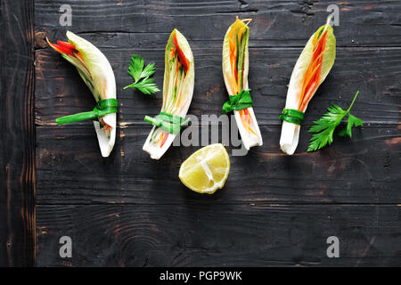 Pflanzliche roll mit chicorée Blätter, Paprika, Karotte und Gurke auf dunklem Hintergrund. Gemüse Snacks. Raw Food Konzept Stockfoto