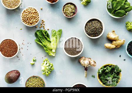 Raw Set Samen, Getreide, Bohnen, Superfoods und grünes Gemüse auf blauen Stein Hintergrund der Ansicht von oben oder vegetarische Ernährung Food Konzept Stockfoto