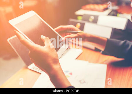 Geschäftsdokumente auf Bürotisch mit Smartphone und digital-Tablette und Grafik mit sozialen Netzwerk-Diagramm und Mann arbeitet in der staatlich finanzielle Stockfoto