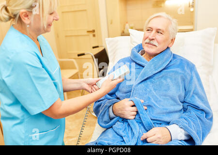 Krankenschwester sorgt für einen älteren Patienten im Pflegeheim Stockfoto