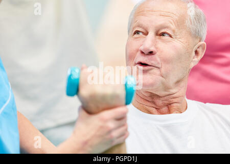 Ältere Menschen tun eine rehab Übung mit Hanteln in den Kurs für Physiotherapie Stockfoto